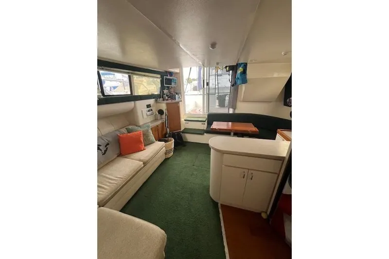 Slide: The Image of 1994 Mainship 40 Sedan Bridge interior with cozy seating and green carpet. - 10