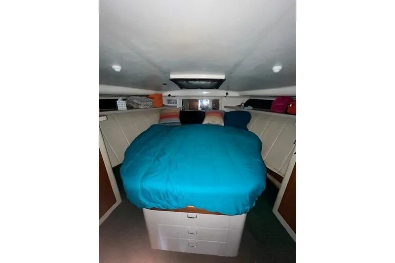 Slide: The Image of 1994 Mainship 40 Sedan Bridge cabin with blue bedding and storage drawers. - 12