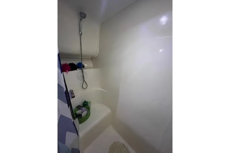 Slide: The Image of Shower area in 1994 Mainship 40 Sedan Bridge boat, featuring a handheld showerhead and storage shelf. - 17