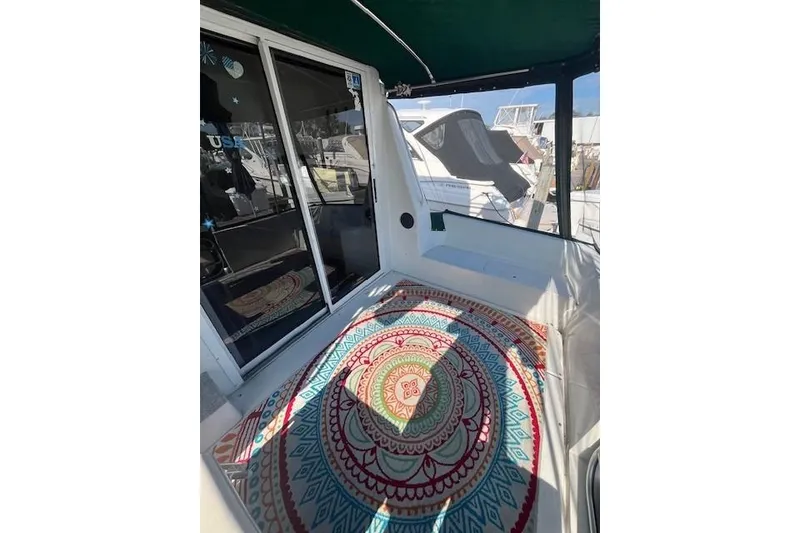 Slide: The Image of 1994 Mainship 40 Sedan Bridge deck with colorful mandala rug and sliding glass doors. - 3