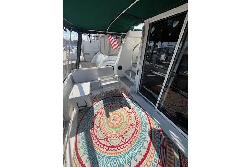 Slide: The Image of 1994 Mainship 40 Sedan Bridge boat interior with colorful rug and seating area. - 4