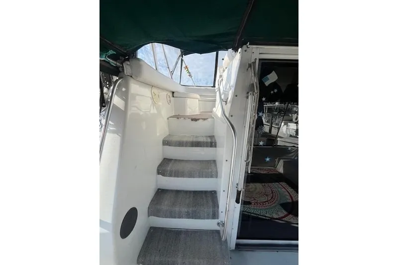 Slide: The Image of 1994 Mainship 40 Sedan Bridge interior stairs with carpet and railing. - 5