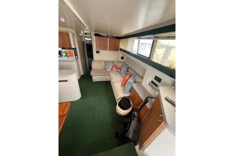 Slide: The Image of Interior of 1994 Mainship 40 Sedan Bridge with cozy seating and green carpet. - 9