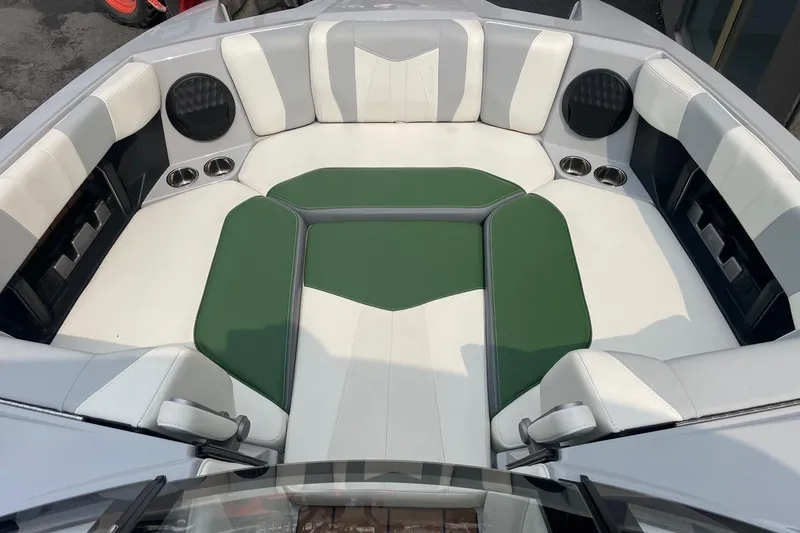 Slide: The Image of 2023 Malibu Wakesetter 24 MXZ boat interior with green and white seating. - 4