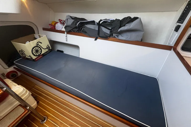 Slide: The Image of Interior of 2003 J Boats J/105 sailboat with blue cushion and storage items. - 19