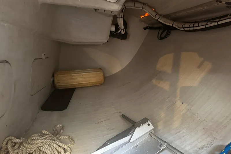 Slide: The Image of Interior of a 2003 J Boats J/105 sailboat, showing storage area with rope and fender. - 25