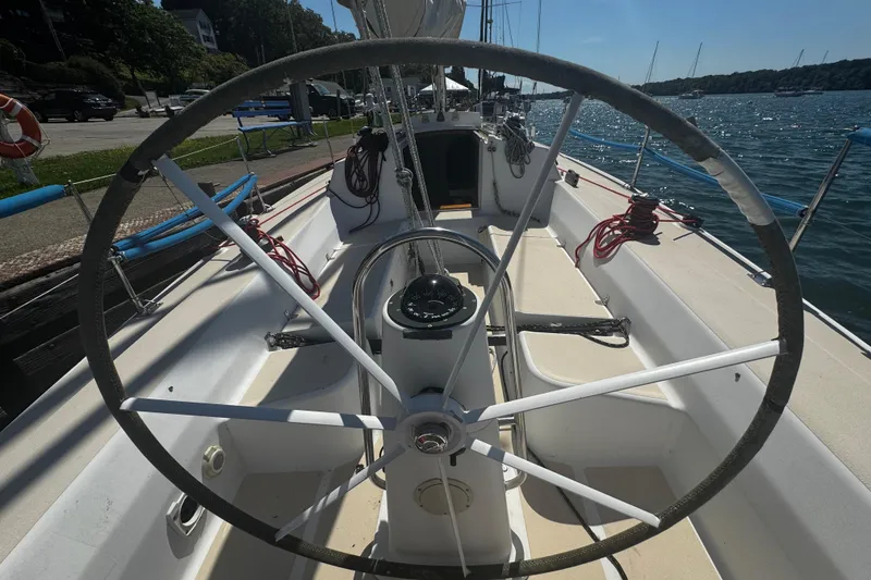 Slide: The Image of 2003 J Boats J/105 sailboat cockpit with steering wheel, docked by the water. - 3
