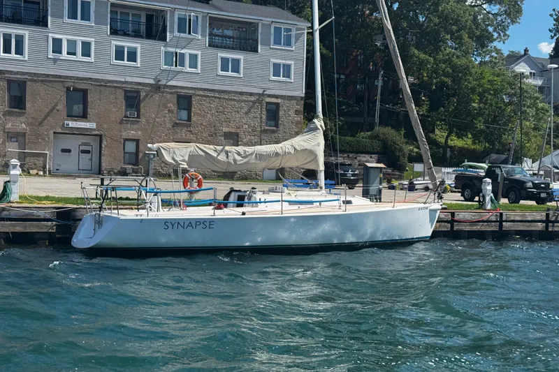 Slide: The Image of 2003 J Boats J/105 sailboat named Synapse docked by a waterfront building. - 33