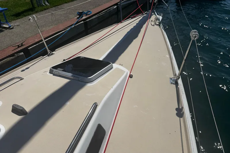 Slide: The Image of 2003 J Boats J/105 sailboat deck with hatch and rigging by the water. - 5