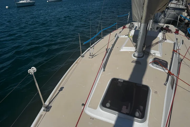 Slide: The Image of 2003 J Boats J/105 sailboat deck with rigging, moored on calm water. - 6