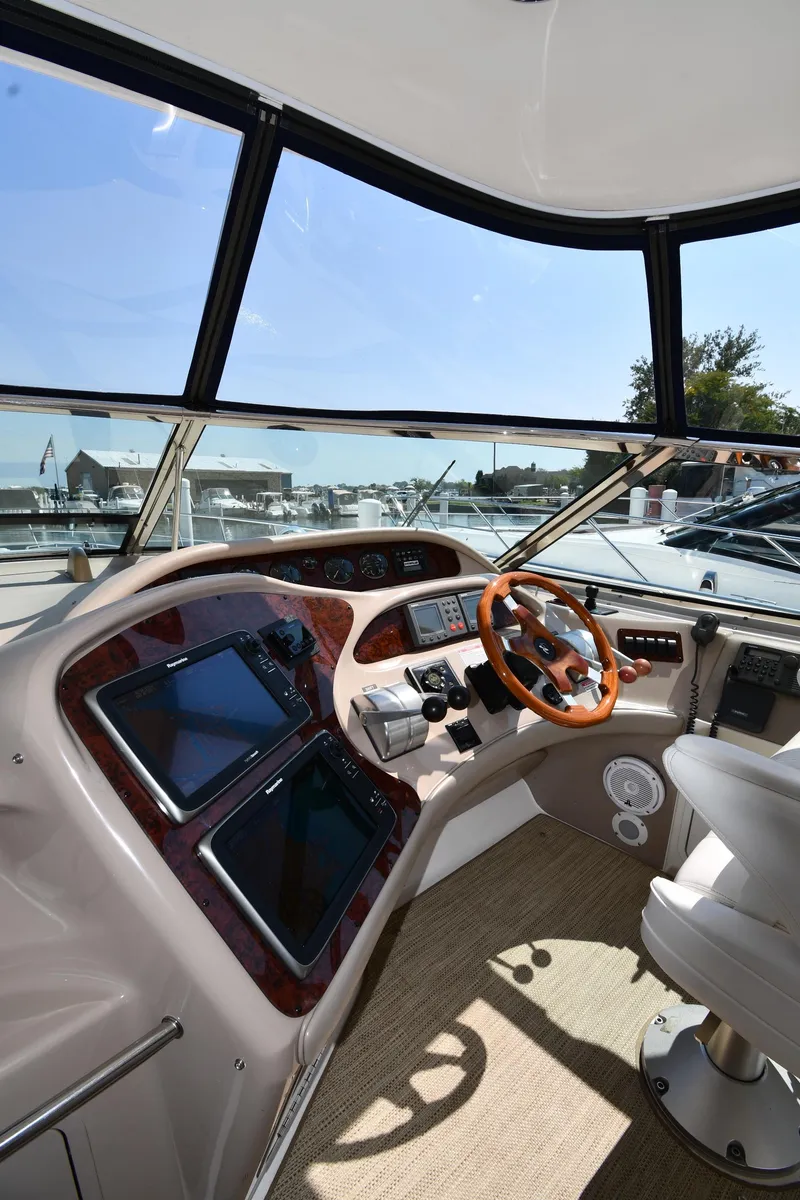 Slide: The Image of 2001 Sea Ray 540 Sundancer helm with dual screens and wooden steering wheel. - 12