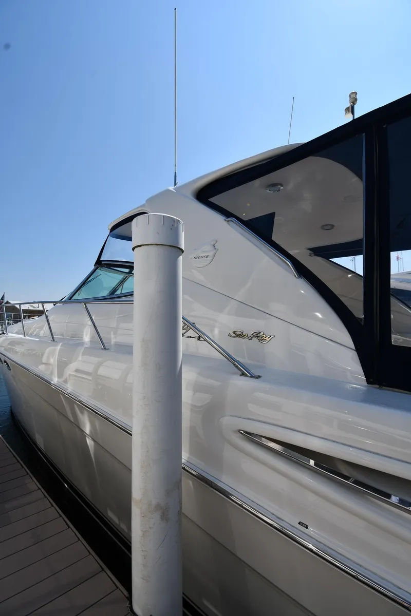 Slide: The Image of 2001 Sea Ray 540 Sundancer yacht docked at marina under clear blue sky. - 2