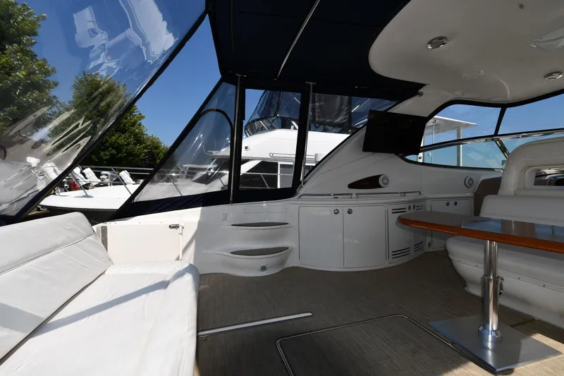 Slide: The Image of 2001 Sea Ray 540 Sundancer interior with seating, table, and cabinetry under a clear canopy. - 21