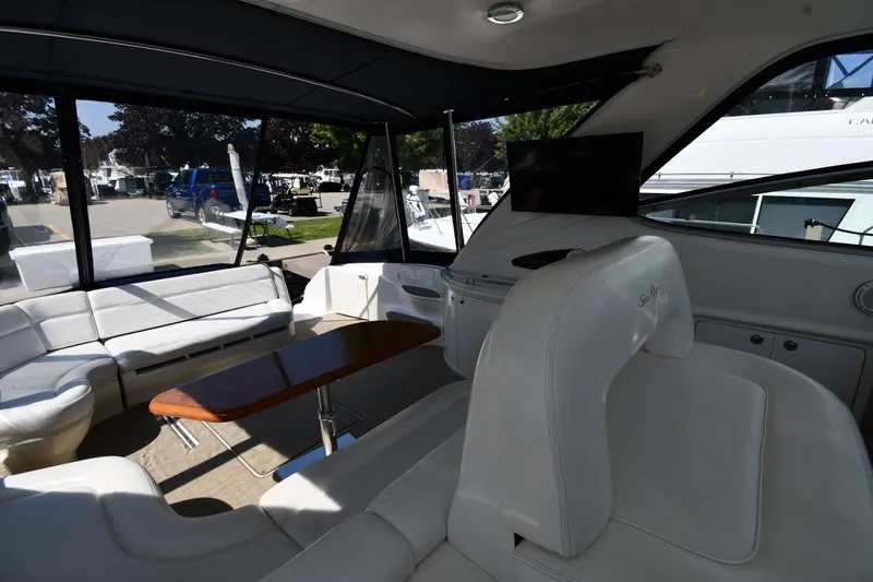 Slide: The Image of Interior of 2001 Sea Ray 540 Sundancer yacht with white seating and wooden table. - 24