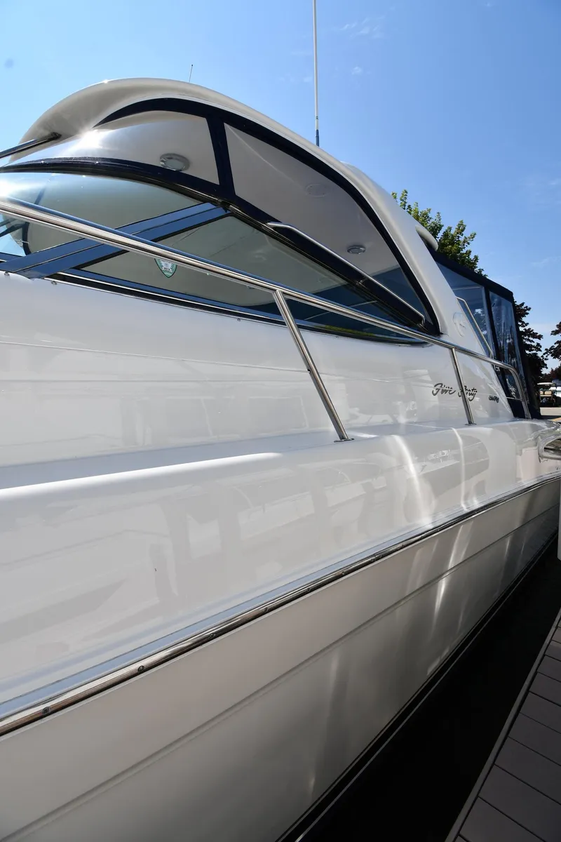 Slide: The Image of 2001 Sea Ray 540 Sundancer yacht, sleek white exterior, docked under clear blue sky. - 3