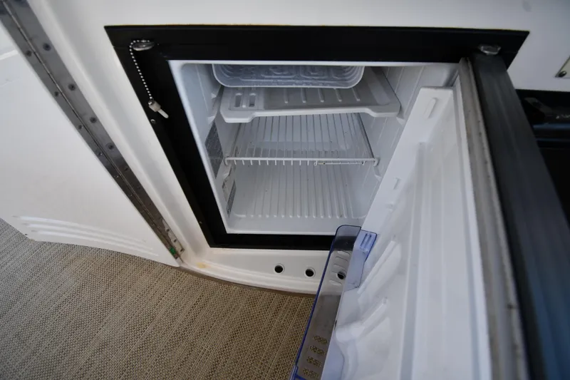 Slide: The Image of Open mini fridge on 2001 Sea Ray 540 Sundancer yacht, showing empty shelves. - 31