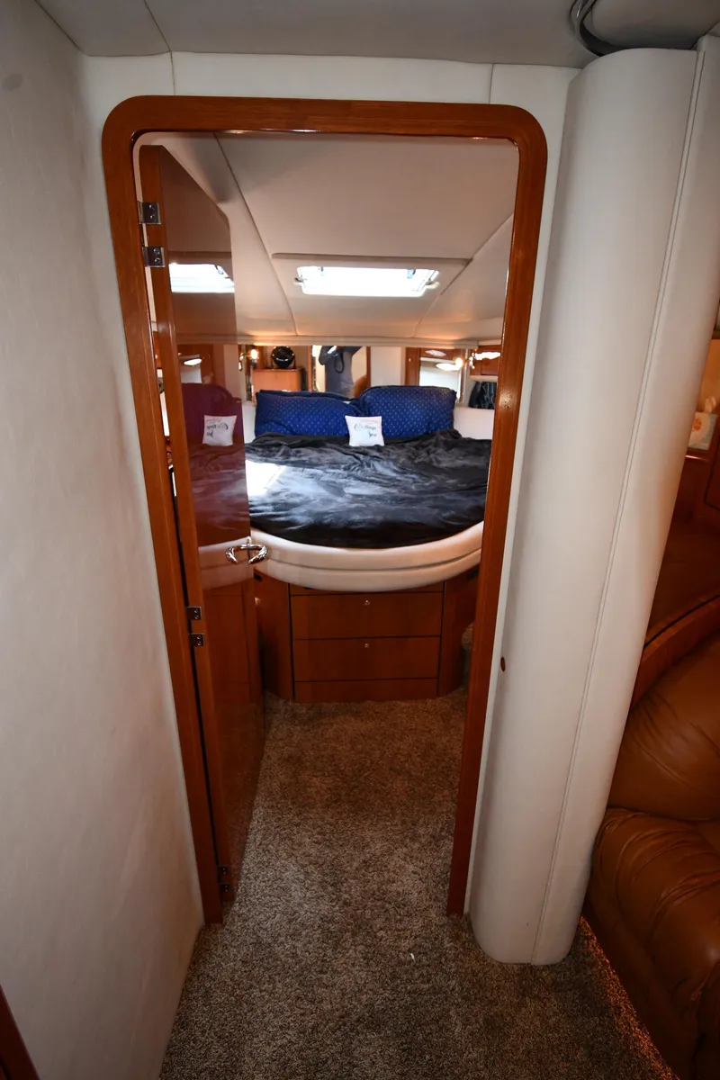 Slide: The Image of 2001 Sea Ray 540 Sundancer cabin interior with bed, wood finish, and carpet flooring. - 34