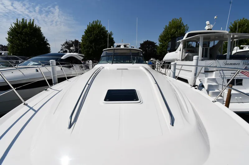 Slide: The Image of 2001 Sea Ray 540 Sundancer yacht docked, viewed from the bow under a clear blue sky. - 5