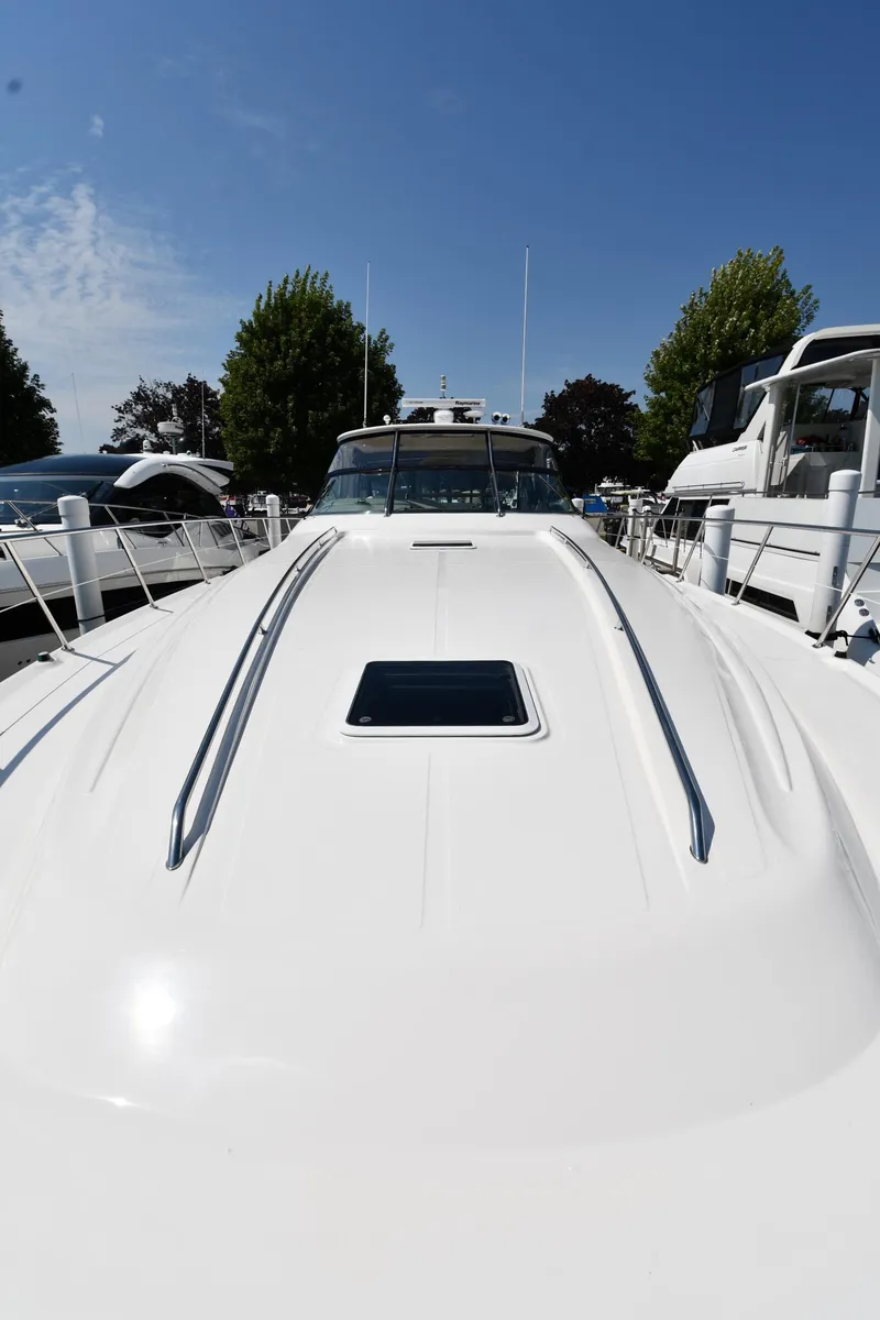Slide: The Image of 2001 Sea Ray 540 Sundancer yacht docked, showcasing sleek white deck under clear blue sky. - 6