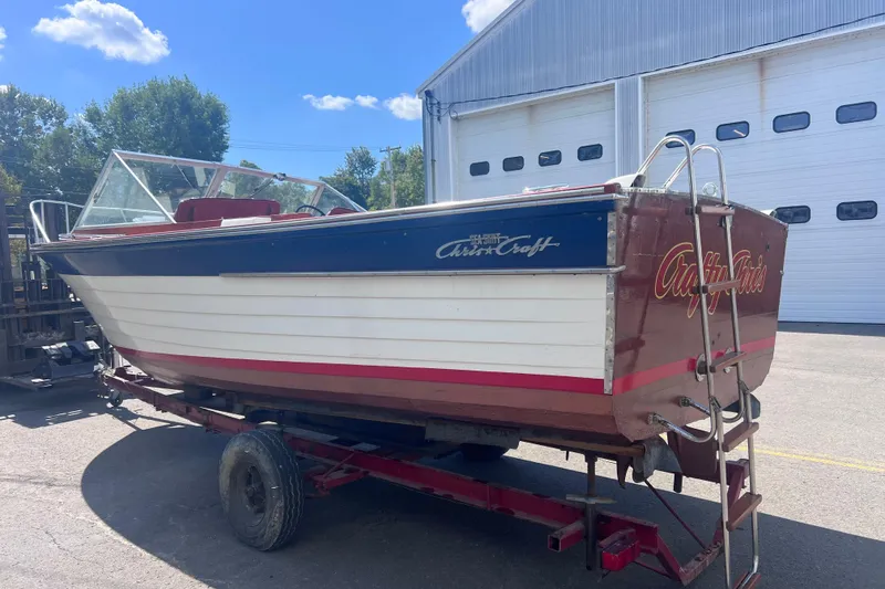 Slide: The Image of 1964 Chris Craft Sea Skiff Sportsman boat on trailer, parked outside a large garage. - 8