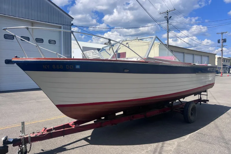 Slide: The Image of 1964 Chris Craft Sea Skiff Sportsman boat on trailer, parked outdoors under blue sky. - 9