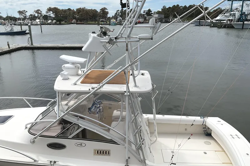Slide: The Image of 2003 Albemarle 27 Express Fisherman boat docked in a marina, featuring fishing equipment. - 31
