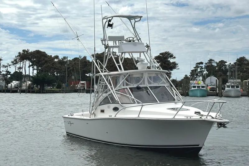 Slide: The Image of 2003 Albemarle 27 Express Fisherman boat on calm water, with marina background. - 4
