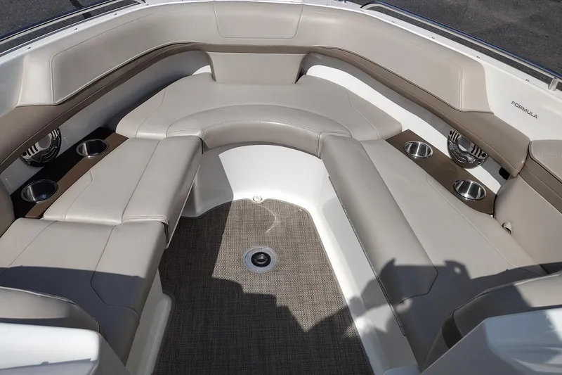 Slide: The Image of 2015 Formula 240 Bowrider interior with beige seating, cup holders, and speakers. - 18