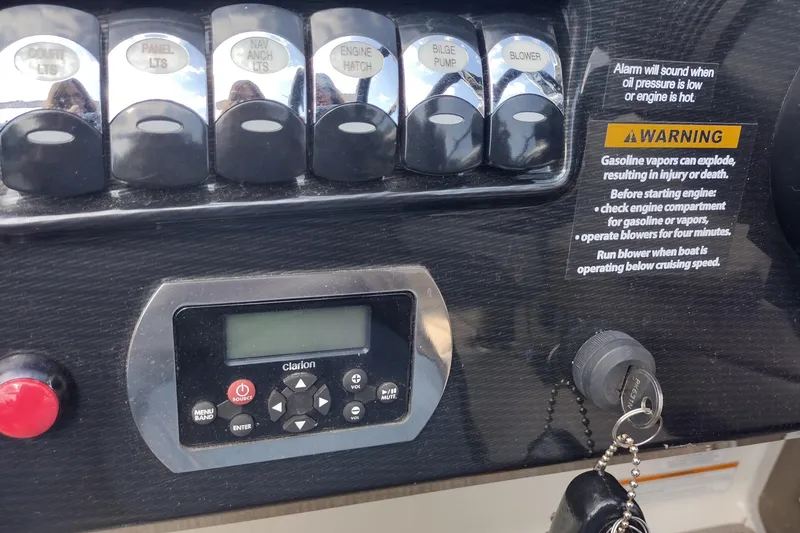 Slide: The Image of Control panel of a 2015 Formula 240 Bowrider with warning labels and Clarion audio system. - 32