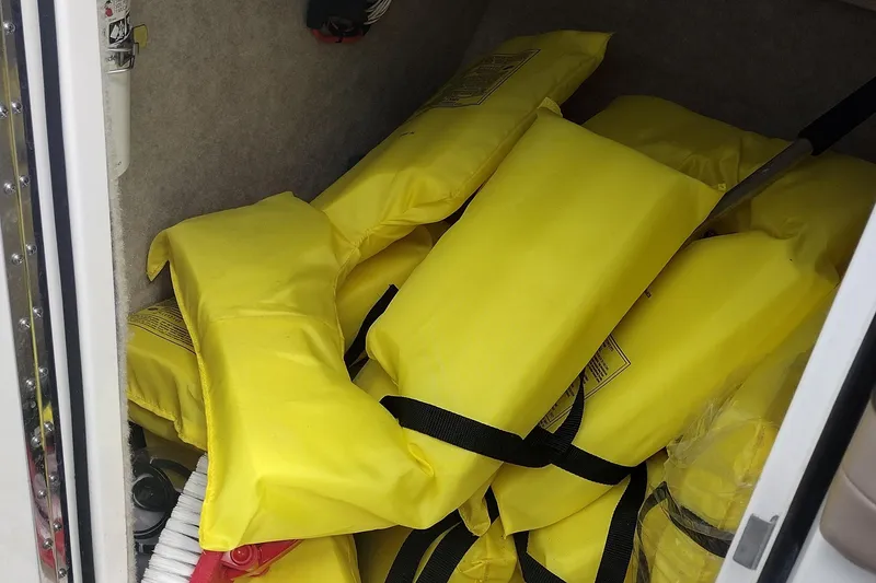 Slide: The Image of Yellow life jackets stored in a 2015 Formula 240 Bowrider boat compartment. - 35