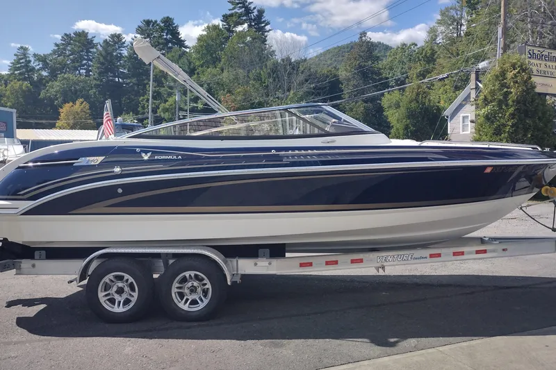 Slide: The Image of 2015 Formula 240 Bowrider boat on trailer, parked outdoors on a sunny day. - 4