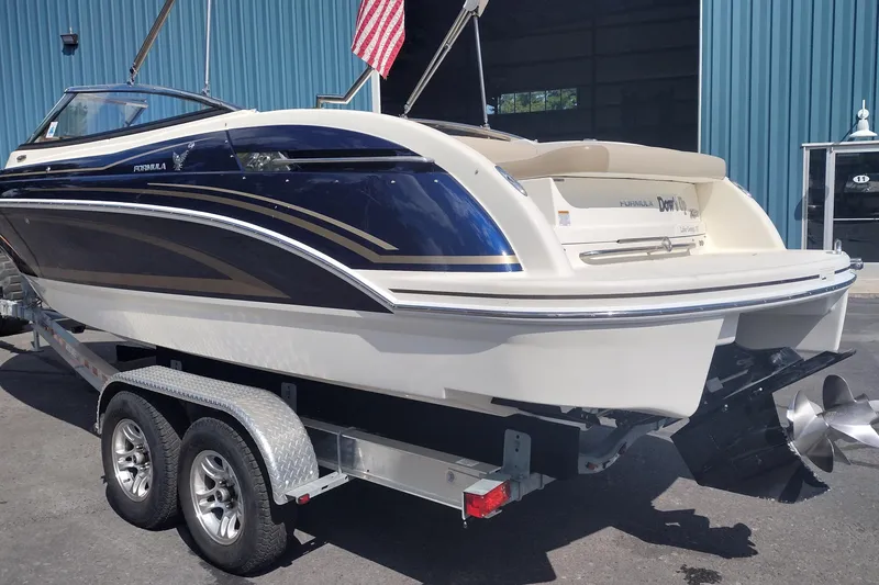 Slide: The Image of 2015 Formula 240 Bowrider boat on trailer, blue and white design, parked outdoors. - 7