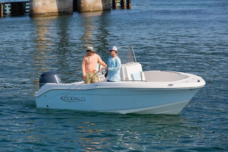Slide: The Image of 2026 Robalo R180 Center Console boat with two people on calm water. - 13