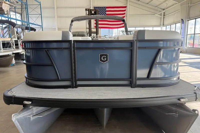 The Image of 2026 Godfrey Sweetwater 2286 C pontoon boat in showroom with American flag backdrop. - 0