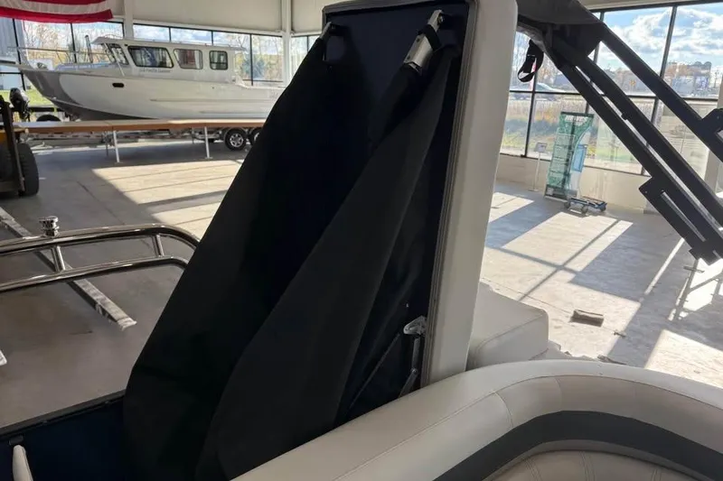 Slide: The Image of 2026 Godfrey Sweetwater 2286 C boat interior with black cover in a showroom. - 11