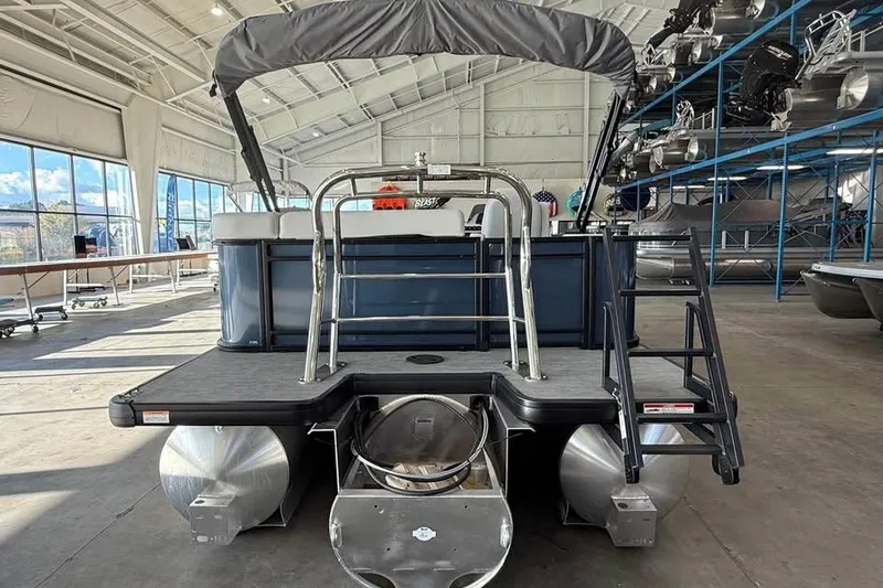 Slide: The Image of 2026 Godfrey Sweetwater 2286 C pontoon boat in a spacious indoor showroom. - 3