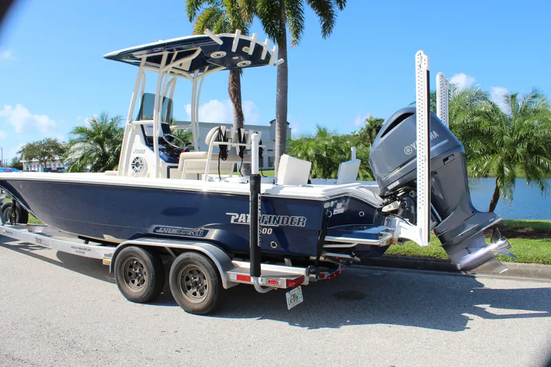 Slide: The Image of 2017 Pathfinder 2500 Hybrid boat on trailer, parked near palm trees and water. - 10