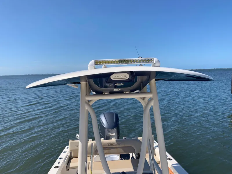 Slide: The Image of 2017 Pathfinder 2500 Hybrid boat on calm water, featuring spacious deck and seating. - 23