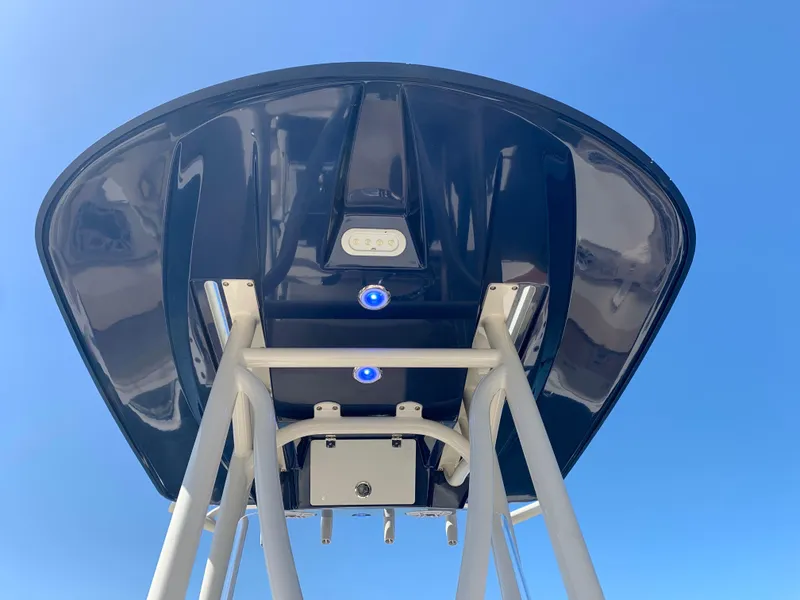 Slide: The Image of 2017 Pathfinder 2500 Hybrid boat T-top with speakers and rod holders against blue sky. - 25