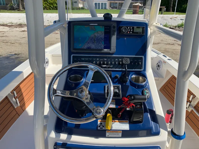 Slide: The Image of 2017 Pathfinder 2500 Hybrid boat interior with steering console, docked on sandy shore. - 43