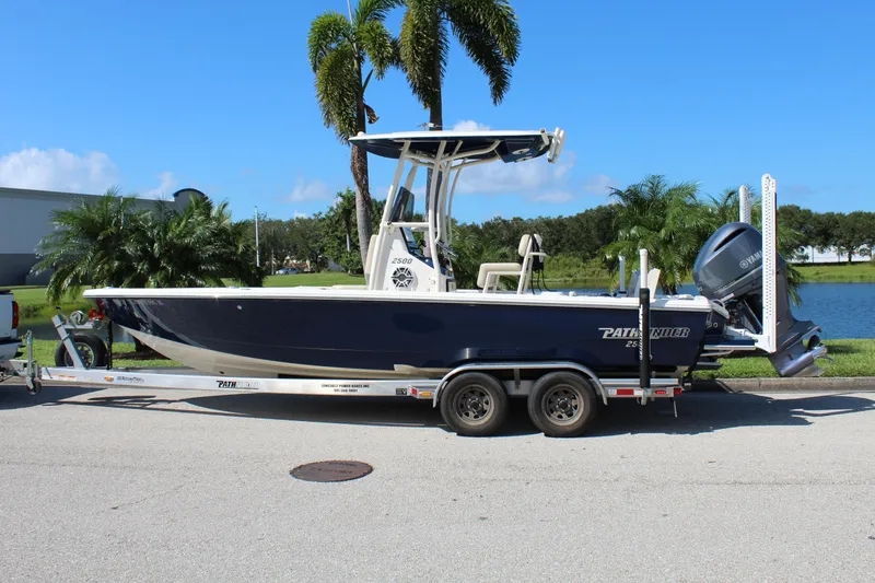 Slide: The Image of 2017 Pathfinder 2500 Hybrid boat on trailer, parked near palm trees. - 6