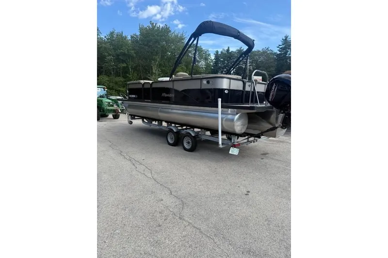 Slide: The Image of 2022 Manitou 23 Aurora LE RF pontoon boat on trailer, parked outdoors. - 1