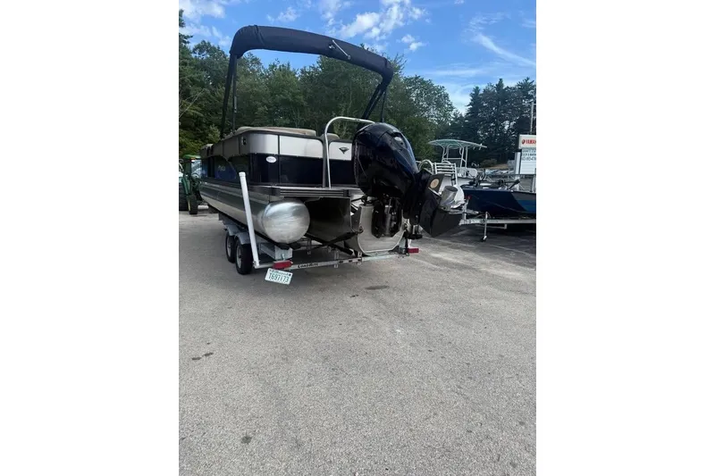 Slide: The Image of 2022 Manitou 23 Aurora LE RF pontoon boat on trailer, parked outdoors. - 2