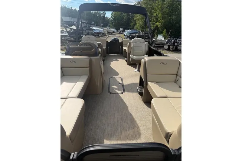 Slide: The Image of 2022 Manitou 23 Aurora LE RF pontoon boat interior with beige seating and open layout. - 3