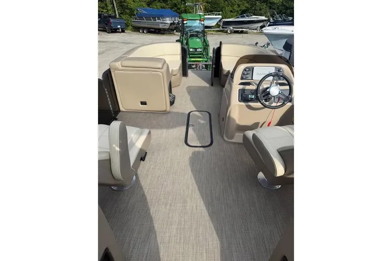 Slide: The Image of 2022 Manitou 23 Aurora LE RF boat interior with beige seating and steering console. - 6