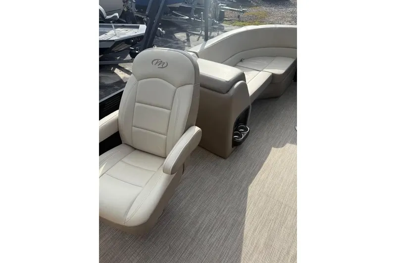 Slide: The Image of Luxurious seating on 2022 Manitou 23 Aurora LE RF boat, featuring plush beige upholstery. - 8