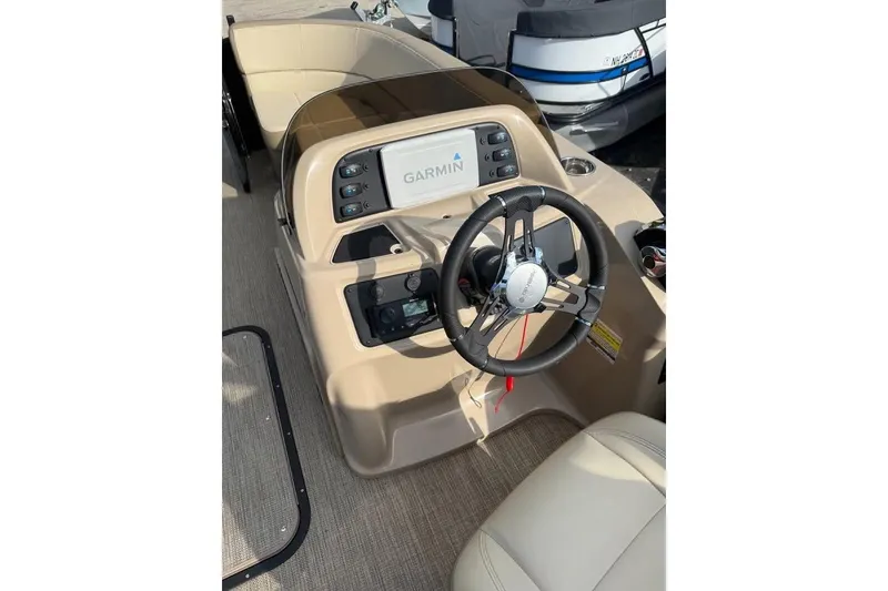 Slide: The Image of 2022 Manitou 23 Aurora LE RF boat dashboard with Garmin navigation system and steering wheel. - 9