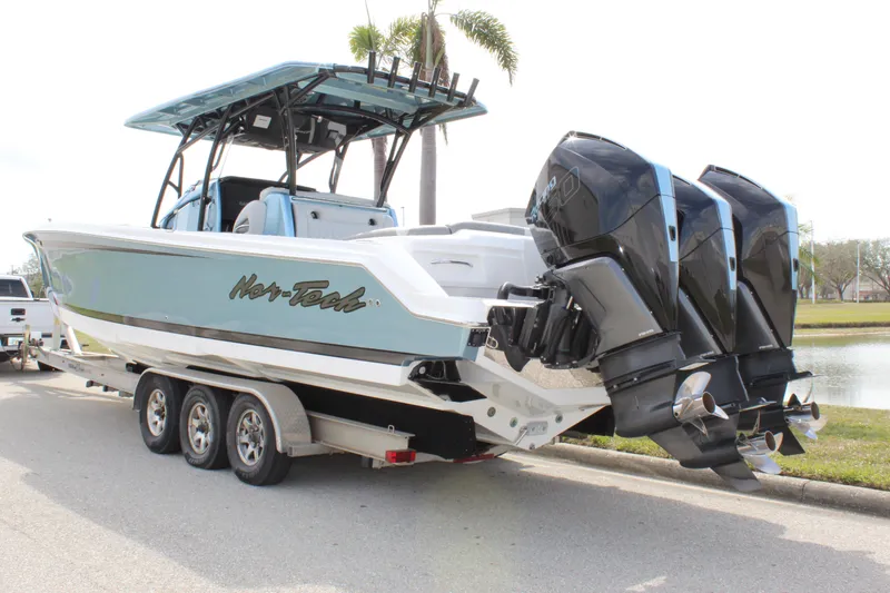 Slide: The Image of 2021 Nor-Tech 390 Sport Center Console boat on trailer with triple outboard engines. - 10