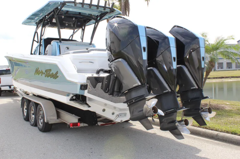 Slide: The Image of 2021 Nor-Tech 390 Sport Center Console boat with triple outboard engines on a trailer. - 11