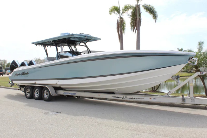 Slide: The Image of 2021 Nor-Tech 390 Sport Center Console boat on trailer, palm trees in background. - 13